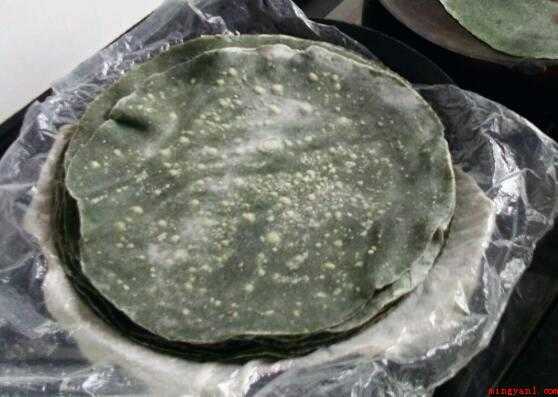 温岭麦饼筒面皮怎么做(艾草煮熟滤水,切碎或手捏碾一下,擀出又大又圆的薄饼皮)